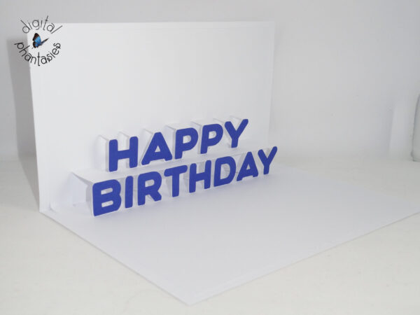 A greeting card with a white base, with a white insert that has the words Happy Birthday that pop up. Individual letters spelling Happy Birthday in blue are glued to the white insert of the card. Card is shown at an angle, so the pop up can be seen