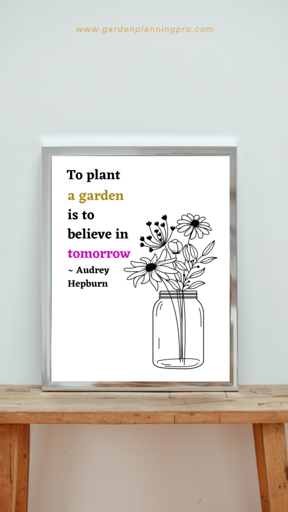 picture frame on a table with wildflowers in a vase and a gardening quote with pink and gold lettering